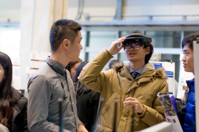 Hopkins graduate students try out a virtual reality headset at a poster demonstration.