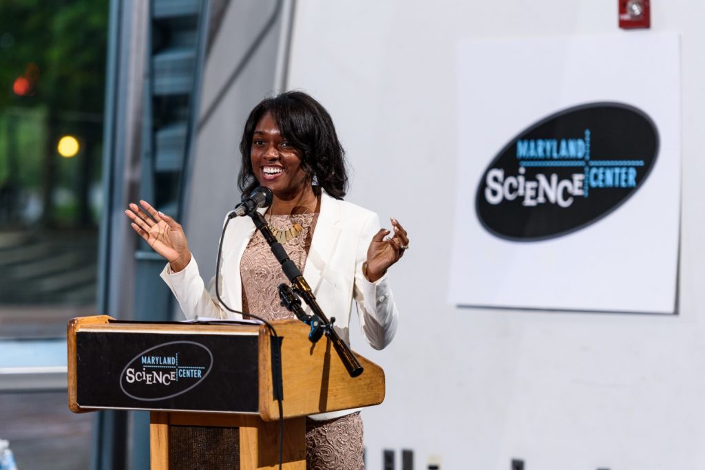 Muyinatu Bell speaks from behind a podium at the Maryland Science Center.
