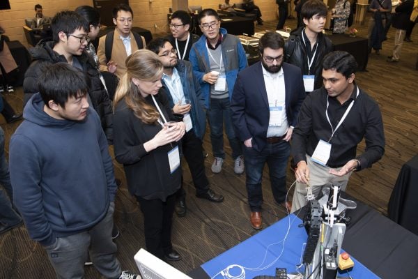 Symposium attendees watch a robotics demonstration.