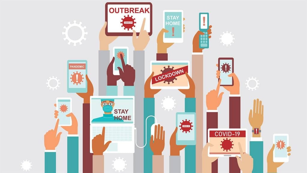 An illustration of many hands holding smartphones, smartwatches, tablets, and laptops with coronavirus molecule and masking imagery on their screens. Words like "OUTBREAK," "COVID-19," "STAY HOME," "PANDEMIC," "LOCKDOWN", and exclamation points accompany the imagery. Coronavirus molecules hover in the air.
