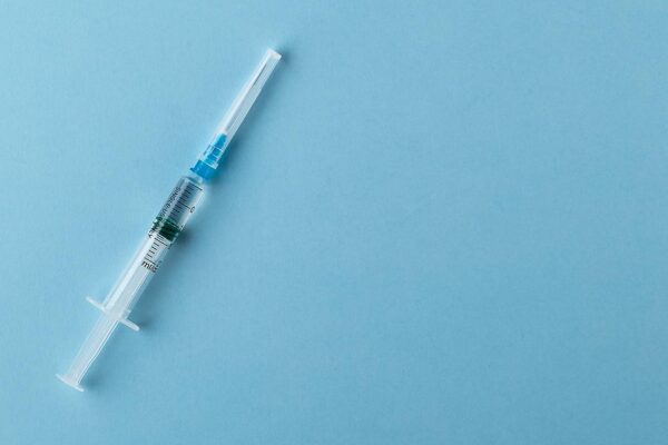 A syringe on a blue background.