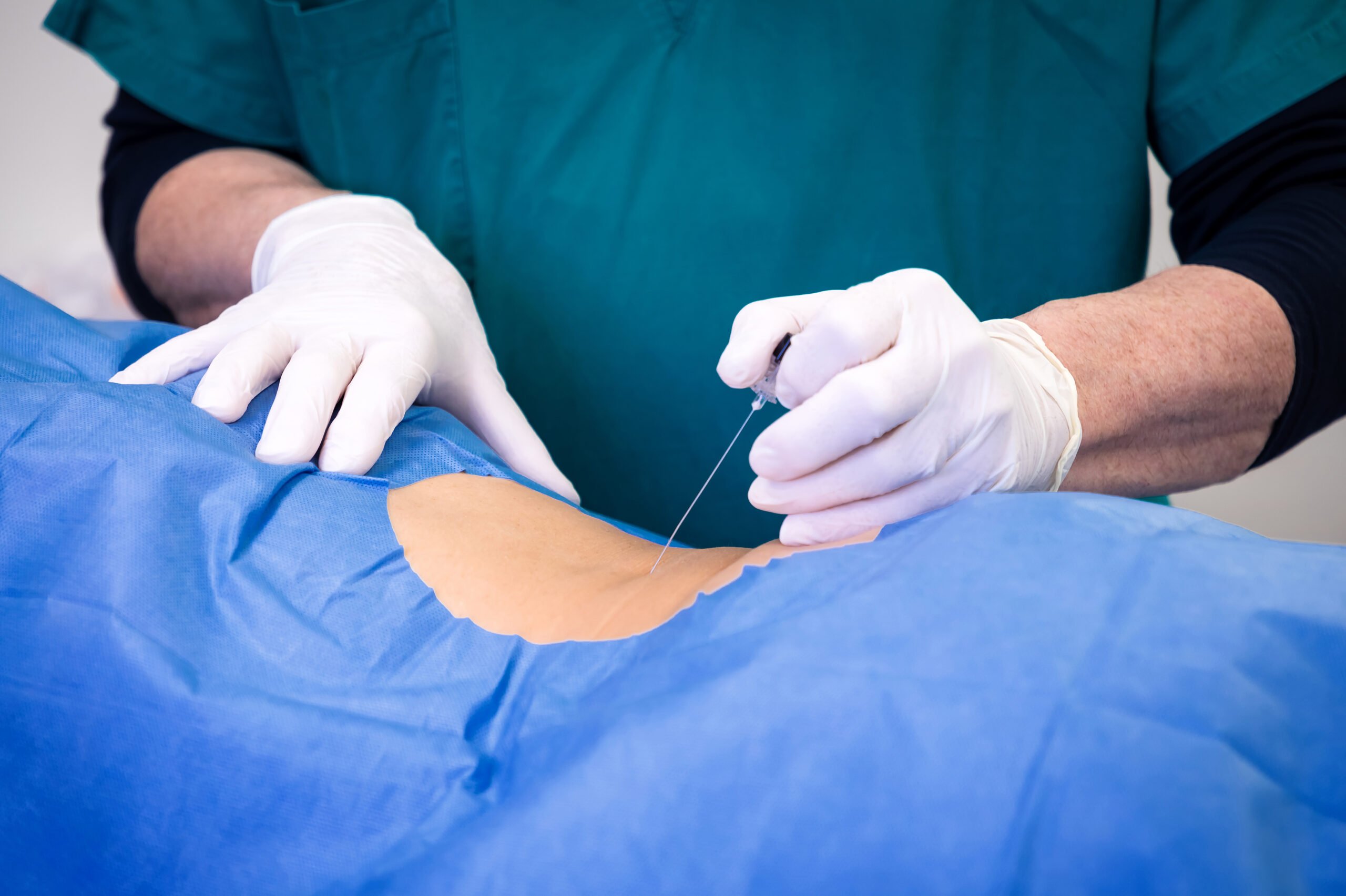 A doctor performs a lumbar puncture on a patient.